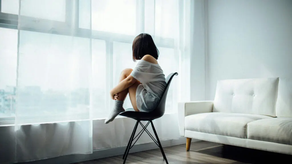 sad woman in front of window