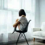sad woman in front of window